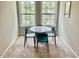 Sunlit dining area featuring a round table and blue chairs positioned between two large windows at 166 Gulley Glen Dr, Garner, NC 27529