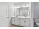 Bathroom with double vanity, white cabinets, light countertop, framed mirror and modern fixtures at 1727 Pinecliff Ct, Fuquay Varina, NC 27526