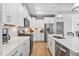 Well-equipped kitchen featuring white cabinets, stainless steel appliances, modern countertops, and tiled backsplash at 1727 Pinecliff Ct, Fuquay Varina, NC 27526