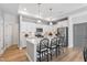 Bright kitchen features white cabinets, stainless steel appliances, pendant lighting, and a center island with seating at 1727 Pinecliff Ct, Fuquay Varina, NC 27526