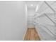 Walk-in pantry with wooden floor and shelving, offering ample storage space for groceries and household items at 1727 Pinecliff Ct, Fuquay Varina, NC 27526