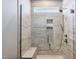 Walk-in shower with glass door, bench, rain shower head, handheld sprayer, and a tile surround at 1727 Pinecliff Ct, Fuquay Varina, NC 27526