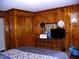 Wood-paneled bedroom with a dresser and a TV, offering a warm and inviting atmosphere at 1809 S Garnett Ext, Henderson, NC 27536