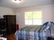 Comfortable bedroom with a blue patterned bedspread and a storage cabinet next to a window at 1809 S Garnett Ext, Henderson, NC 27536
