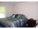 Well-lit bedroom features a bed with stylish blue and silver patterned bedding and hardwood floors at 1809 S Garnett Ext, Henderson, NC 27536