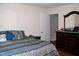 Bedroom with a wooden dresser and blue accent pillows on the bed featuring stylish bedding at 1809 S Garnett Ext, Henderson, NC 27536