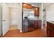 Stainless steel refrigerator with wood cabinets and adjacent laundry room at 2001 October Dr, Durham, NC 27703