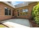 A brick home's outdoor patio with an entrance and large windows allows for plenty of natural light at 2014 Muirfield Ct, Elon, NC 27244