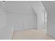 Empty walk-in closet with carpet, built-in shelving, a window, and a small access door at 2014 Muirfield Ct, Elon, NC 27244