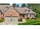 Charming brick home featuring manicured landscaping, a two-car garage, and a cozy front porch at 2014 Muirfield Ct, Elon, NC 27244