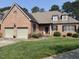 Beautiful red brick home featuring a two-car garage, manicured lawn, and well-kept landscaping at 2014 Muirfield Ct, Elon, NC 27244