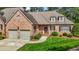 Stately brick home with an attached garage, manicured landscaping, and a welcoming entrance at 2014 Muirfield Ct, Elon, NC 27244