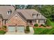 Charming brick home showcasing a two-car garage, dormer windows, and a well-manicured lawn at 2014 Muirfield Ct, Elon, NC 27244