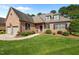 Charming brick home with a well-manicured lawn, lush landscaping, and an attached garage on a sunny day at 2014 Muirfield Ct, Elon, NC 27244