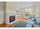 Bright sunroom showcasing a fireplace, ample natural light, and a comfortable blue couch at 2014 Muirfield Ct, Elon, NC 27244