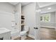 Bathroom featuring a combined tub and shower with wooden shelves and white cabinets at 205 Forest Hill Ave, Rocky Mount, NC 27804