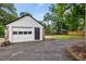 Exterior view of the detached garage with a white door, set in a spacious yard with mature trees at 205 Forest Hill Ave, Rocky Mount, NC 27804