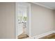 Hallway with hardwood floors and a view to a bright sunroom through a glass paned door at 205 Forest Hill Ave, Rocky Mount, NC 27804