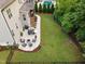 Backyard aerial showcases a patio with a fire pit, an outdoor dining area, and lush landscaping at 2083 Amalfi Pl, Apex, NC 27502