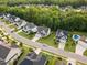 An aerial view of a well-maintained street and homes with mature trees and landscaping at 2083 Amalfi Pl, Apex, NC 27502