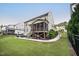 A view of a home's backyard featuring a screened porch, outdoor patio, a well-maintained lawn, and partial fencing at 2083 Amalfi Pl, Apex, NC 27502