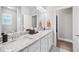Bright bathroom featuring double sinks, granite counters, and white cabinetry with an open doorway leading to another room at 2083 Amalfi Pl, Apex, NC 27502