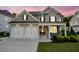 Attractive home with a covered porch, a two-car garage, and manicured landscaping at 2083 Amalfi Pl, Apex, NC 27502