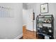 Hallway with hardwood floors, open door and shelving unit at 2083 Amalfi Pl, Apex, NC 27502