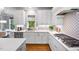 Bright kitchen featuring white cabinets, a stainless steel dishwasher, and decorative backsplash at 2083 Amalfi Pl, Apex, NC 27502