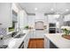Open kitchen with white cabinets, stainless appliances, hardwood floors, and a view to the backyard at 2083 Amalfi Pl, Apex, NC 27502