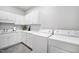A well-lit laundry room featuring modern appliances, white cabinets, and ample counter space at 2083 Amalfi Pl, Apex, NC 27502