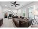 Living room area featuring several windows, sectional couch and a desk setup for home office at 2083 Amalfi Pl, Apex, NC 27502