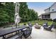 Landscaped backyard patio with a dining set and fire pit providing a cozy outdoor space at 2083 Amalfi Pl, Apex, NC 27502