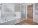 Bright bathroom featuring a soaking tub, glass-enclosed shower, and a linen closet for a spa-like experience at 213 Steel Springs Ln # 22, Angier, NC 27501