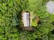 Aerial shot of a private residence with lush green surroundings, a gray roof, and an expansive tree canopy at 221 Jansmith Ln, Raleigh, NC 27615