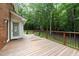 Back deck with wood railing surrounded by trees and greenery at 221 Jansmith Ln, Raleigh, NC 27615
