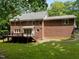 Back exterior elevation of brick home with wood deck and steps to back yard at 221 Jansmith Ln, Raleigh, NC 27615