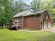 Back exterior elevation of brick home with wood deck, garage, and lawn at 221 Jansmith Ln, Raleigh, NC 27615