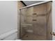 Bathroom shower with tile surround and glass door plus built-in wall shelving at 221 Jansmith Ln, Raleigh, NC 27615