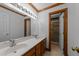 Bathroom featuring a double sink vanity, decorative mirror, and updated shower at 221 Jansmith Ln, Raleigh, NC 27615