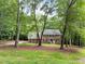 Traditional two-story brick home with a symmetrical facade and a welcoming front porch surrounded by mature trees at 221 Jansmith Ln, Raleigh, NC 27615