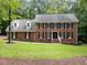 Well-maintained two-story brick home featuring black shutters, dormer windows, and a meticulously manicured green lawn at 221 Jansmith Ln, Raleigh, NC 27615