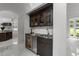 Entertain in style with the bar area boasting dark wood cabinets, a cooler, and marble countertops at 2220 Inwood Landing Ct, Raleigh, NC 27603
