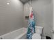 A bathroom with light gray walls, gray floors, white cabinets, and a shower with a floral curtain at 2220 Inwood Landing Ct, Raleigh, NC 27603