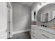 A bathroom with light gray walls, gray floors, white cabinets and a round mirror at 2220 Inwood Landing Ct, Raleigh, NC 27603