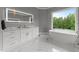An elegant bathroom featuring marble floors, a large window, and a standalone tub at 2220 Inwood Landing Ct, Raleigh, NC 27603