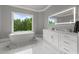 An elegant bathroom featuring marble floors, a standalone tub, and a large vanity mirror at 2220 Inwood Landing Ct, Raleigh, NC 27603