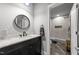Modern bathroom with a glass enclosed shower, updated fixtures, a black vanity with white countertop, and round mirror at 2220 Inwood Landing Ct, Raleigh, NC 27603