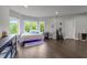 A gray bedroom with wood floors, large windows, a bed with blue lighting, and other furnishings at 2220 Inwood Landing Ct, Raleigh, NC 27603