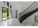 Elegant foyer with marble floors, high ceilings, statement staircase and black trim door, creating a luxurious entrance at 2220 Inwood Landing Ct, Raleigh, NC 27603
